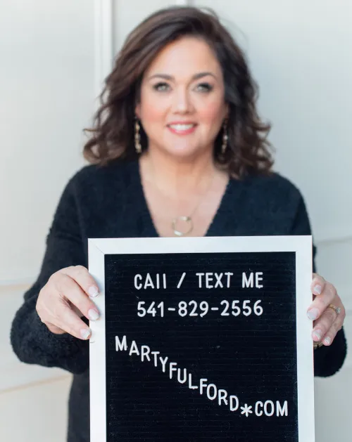 Marty Fulford holding a letter board that reads call or text me